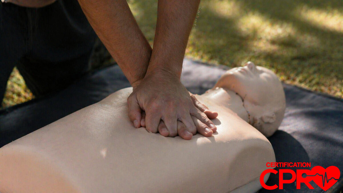 Person performing hands-only CPR on a mannequin outdoors in Jacksonville.